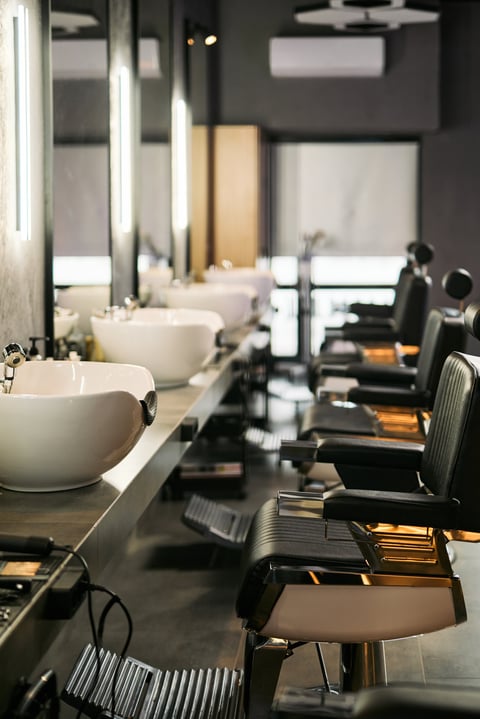 Modern salon interior with barber chairs and wash basins
